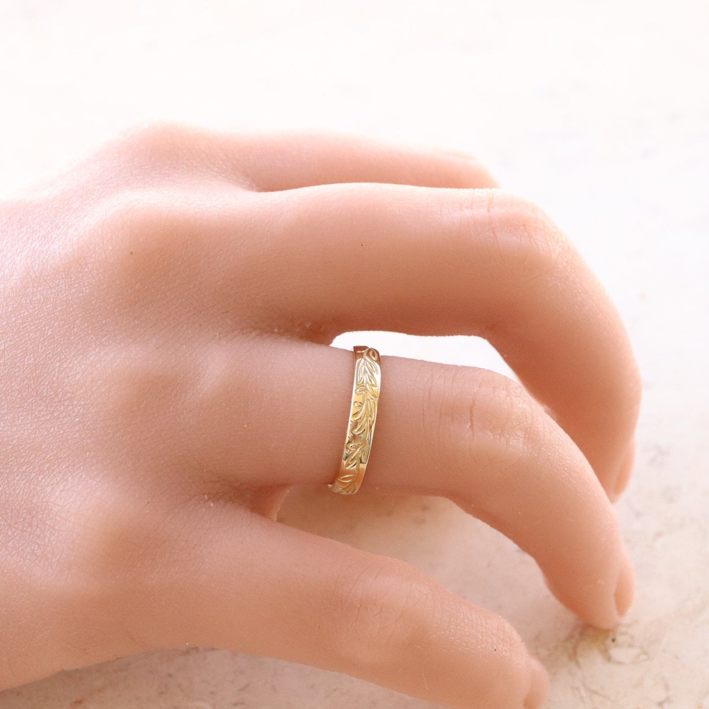 Graceful Gold Leaf Wedding Band elegantly adorns a woman's hand